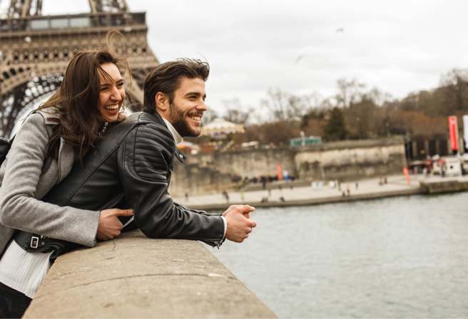 Two people smiling in front of the Eiffel Tower